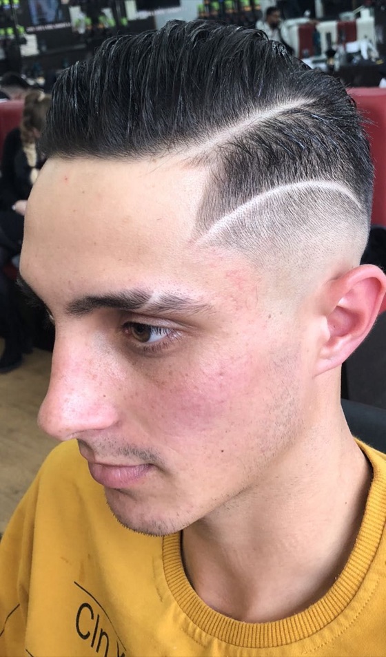 Hard part comb over with a high skin fade